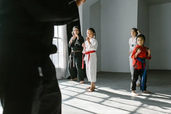 martial arts class with students wearing colored belts training together