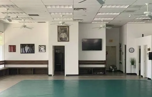 spacious martial arts dojo with training mats and wall-mounted television