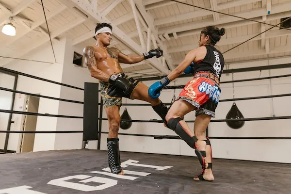 muay thai fighters sparring in gym ring during kickboxing training session